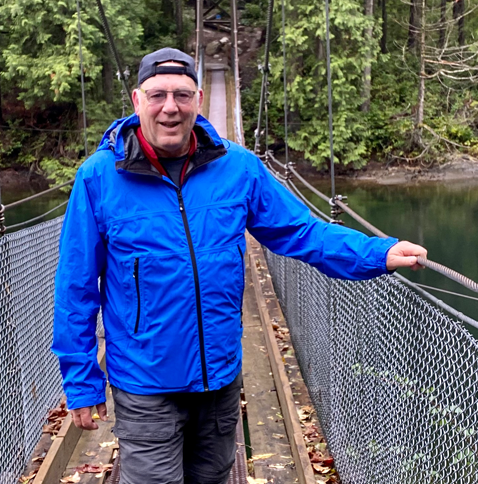 Photo of man standing on a suspension bridge